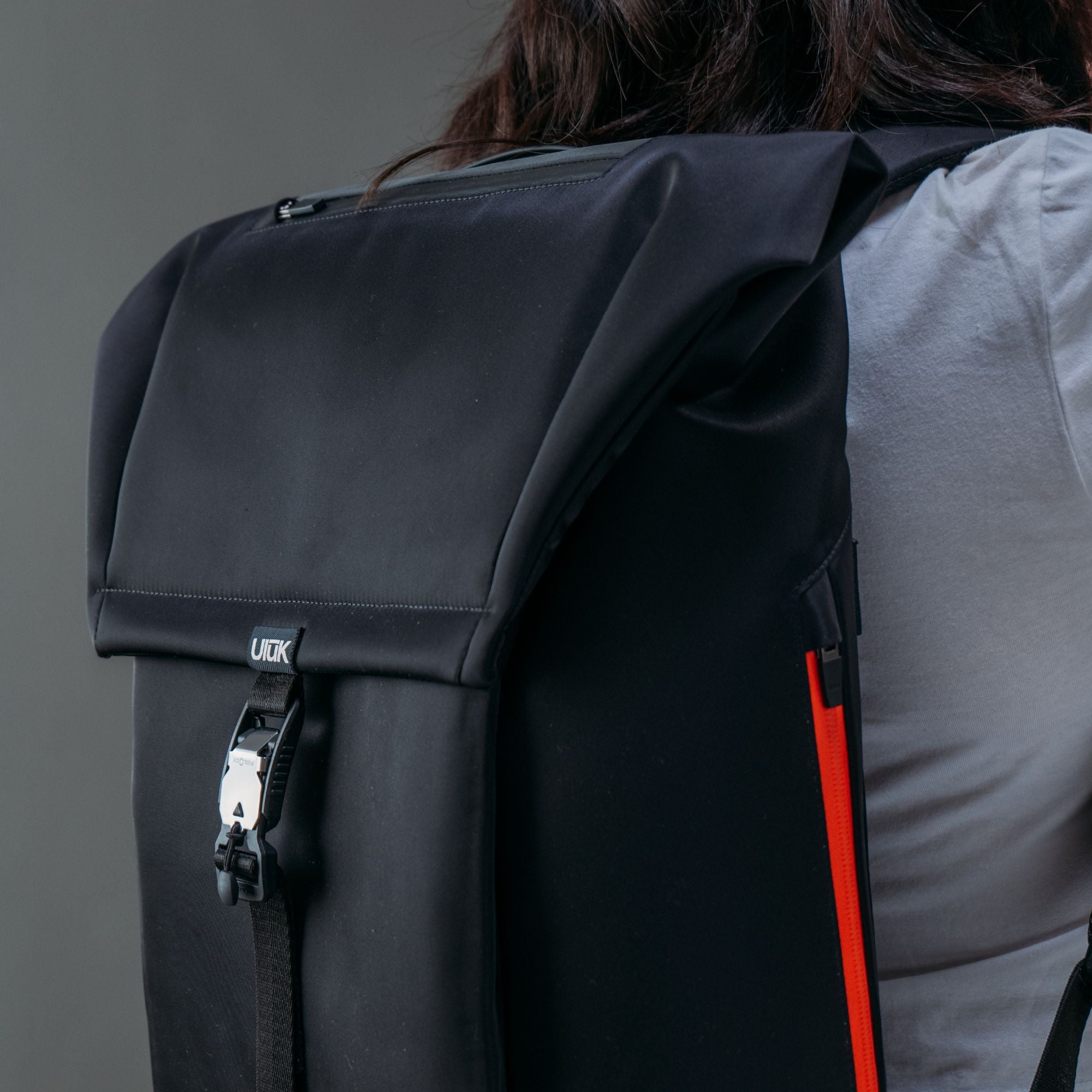 Close-up of the front Fidlock magnetic closure buckle on the black daypack.