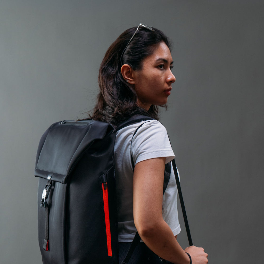 Side view of a person wearing the sleek black Ulūk Outdoors EDC.20 backpack.