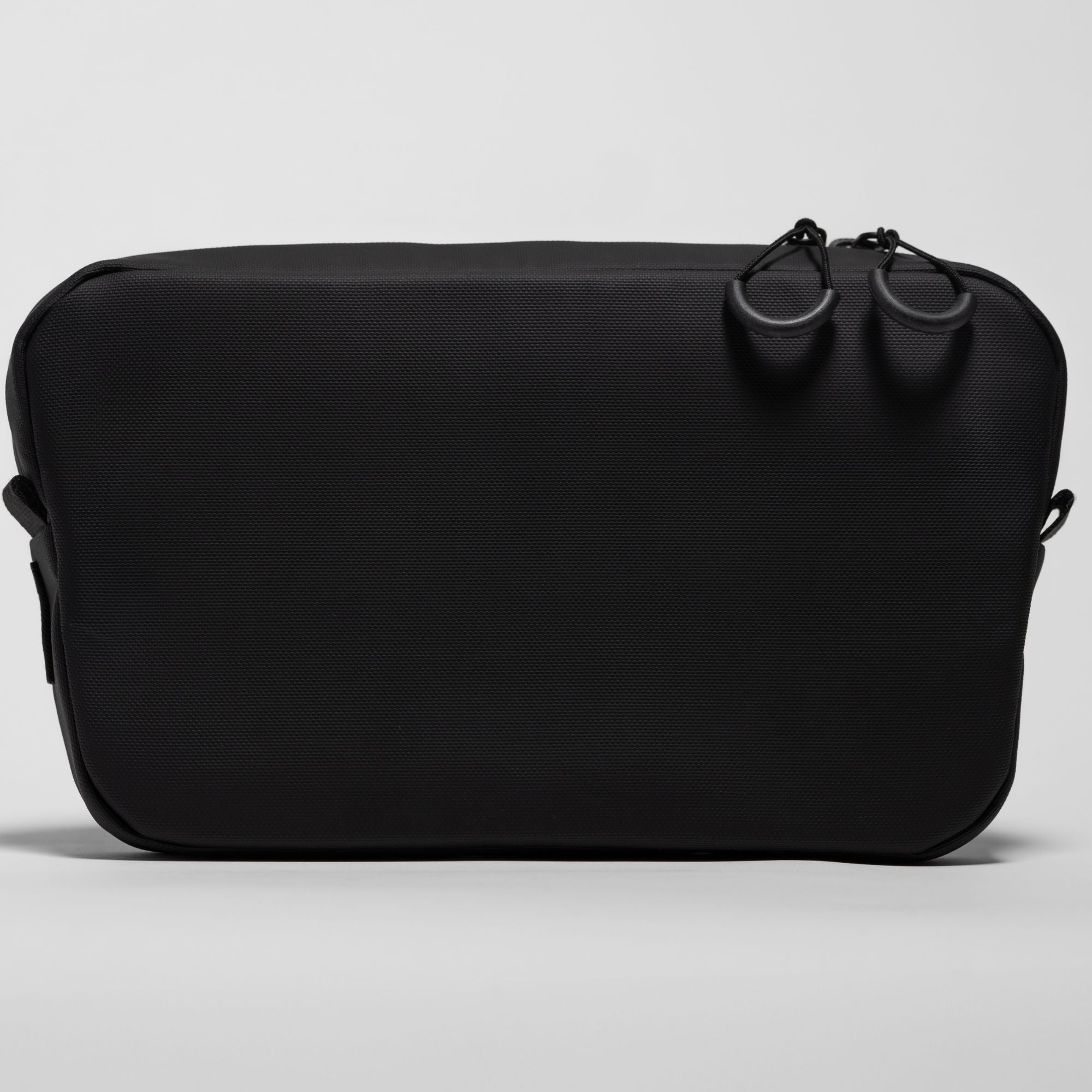 Straight back view of the black Ulūk Outdoors EDC.2L TPU sling bag.