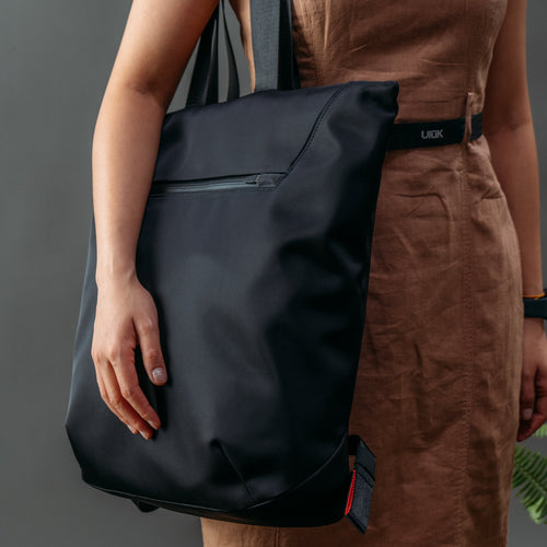 ULŪK EDC.15 Totepack side view showing convertible tote and backpack carry modes with ergonomic straps