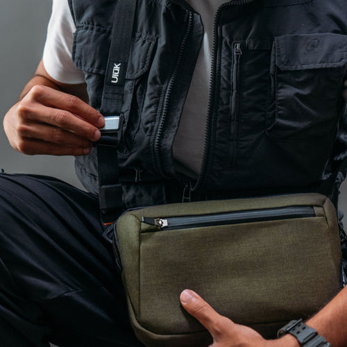 ULŪK EDC.2L Cordura Olive Sling crossbody carry showcasing ergonomic strap system and urban outdoor style